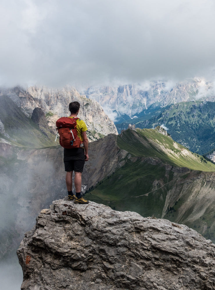 Escursionista tra nebbia e cime nelle Dolomiti